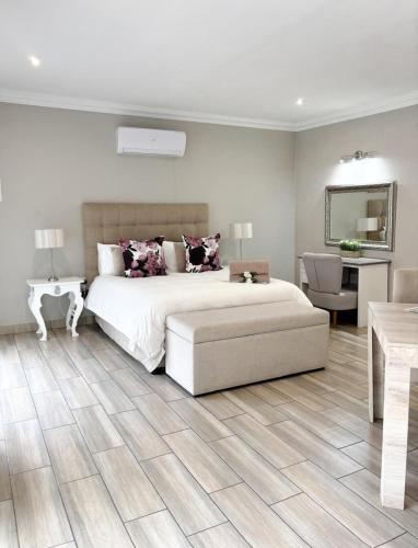 a bedroom with a large bed and a table and a couch at Bella Rosa in Potchefstroom
