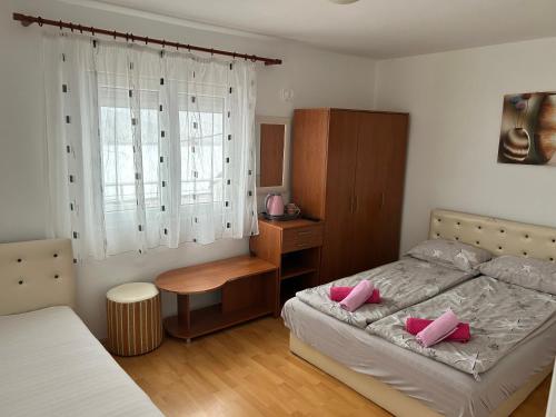 a bedroom with a bed with pink pillows on it at Vila Dunjić Prolom Banja in Prolomska Banja