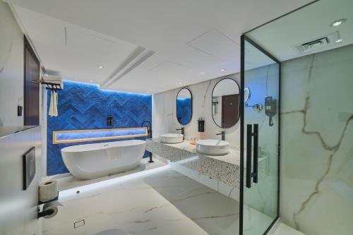 a bathroom with two sinks and two mirrors at Ramada Hotel, Suites and Apartments by Wyndham Dubai JBR in Dubai