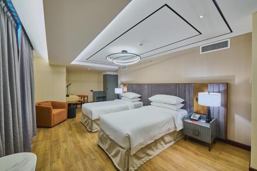 a hotel room with two beds and a couch at Ramada Hotel, Suites and Apartments by Wyndham Dubai JBR in Dubai