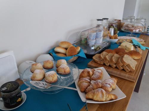 a table filled with different types of bread and pastries at Home Scala dei Turchi B&B in Realmonte