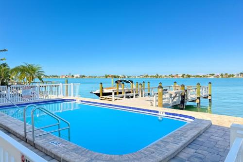 a large swimming pool next to a body of water at 107 · Boat dock- BBQ Walk to Beach GREAT VIEWS in St. Pete Beach