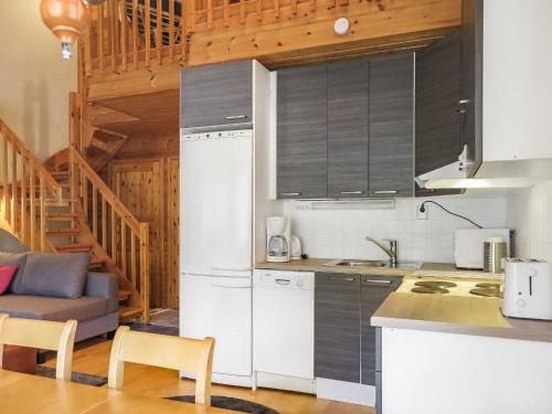 a kitchen with a white refrigerator and a table at Holiday Home Artturi by Interhome in Levi