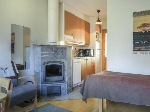 a living room with a fireplace and a kitchen at Holiday Home Moitakuru a5 by Interhome in Saariselka
