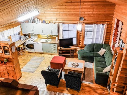 a living room with a green couch and a kitchen at Holiday Home Villemi by Interhome in Saariselka