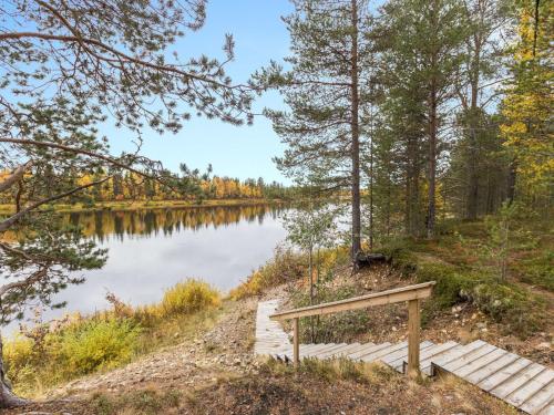 a wooden bench sitting next to a lake at Holiday Home Suvantovirta by Interhome in Kaukonen