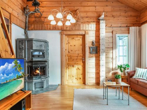 a living room with a fireplace in a log cabin at Holiday Home Ojala by Interhome in Virta