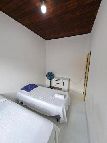a bedroom with two beds and a wooden ceiling at CASA DE HOSPEDAGEM FLORES PARATY AMBIENTE FAMILIAR 600M do CENTRO in Paraty
