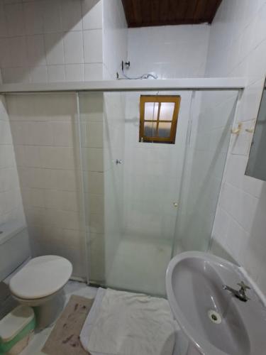 a white bathroom with a toilet and a sink at CASA DE HOSPEDAGEM FLORES PARATY AMBIENTE FAMILIAR 600M do CENTRO in Paraty