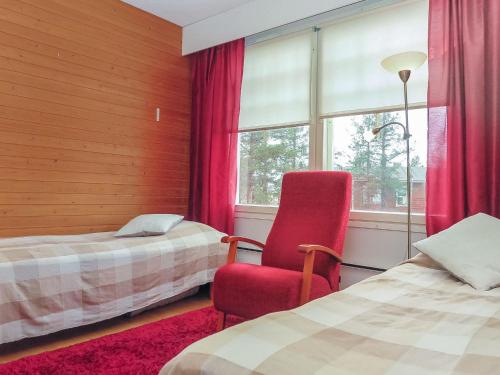 a room with two beds and a chair and a window at Holiday Home Moitakuru a14 by Interhome in Saariselka