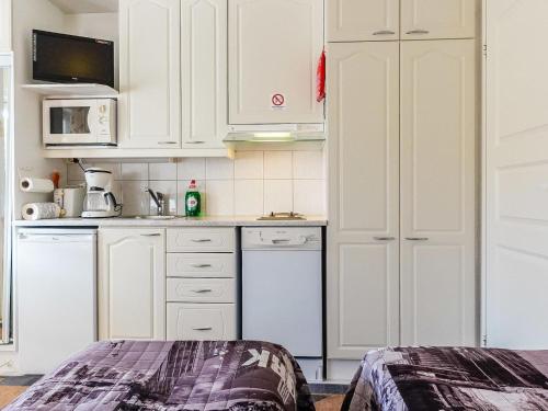 a kitchen with white cabinets and a dishwasher at Holiday Home Levi star 1503 by Interhome in Levi