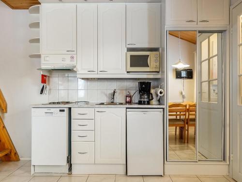 a kitchen with white cabinets and a microwave at Holiday Home Moonlight 201 by Interhome in Levi