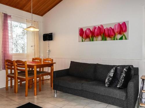 a living room with a couch and a table with red tulips at Holiday Home Moonlight 201 by Interhome in Levi