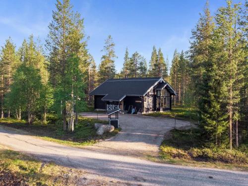 a log cabin in the woods next to a road at Holiday Home Aspilevi by Interhome in Levi