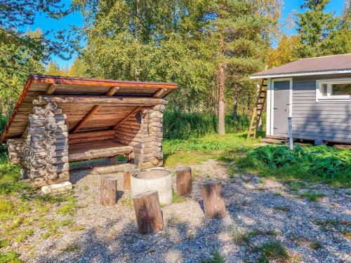 a log cabin in a yard next to a house at Holiday Home Mukan maja by Interhome in Köngäs
