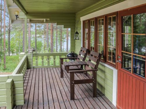 a porch with two benches on a wooden deck at Holiday Home Saikulevi by Interhome in Levi