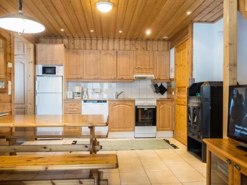 a kitchen with wooden cabinets and a wooden table at Holiday Home Hirvas levi 2 by Interhome in Levi