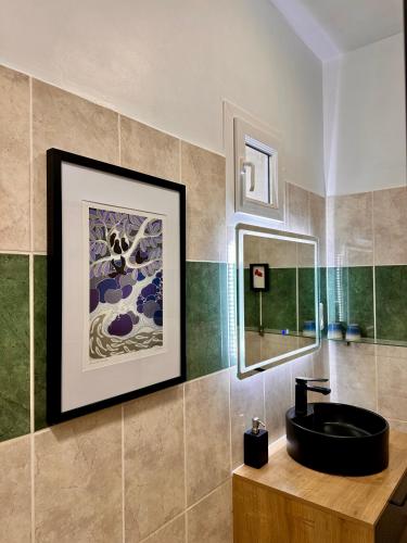 a bathroom with a black sink and a mirror at L'Ostal de Soubrey in Salettes