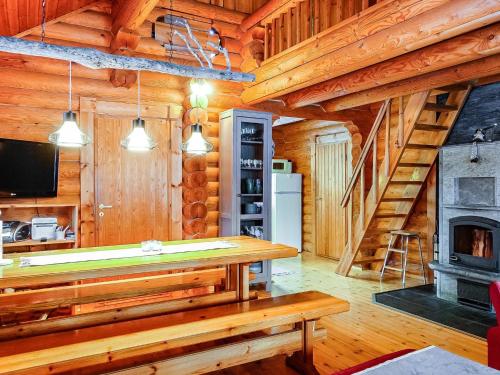 a log cabin with a table and a fireplace at Holiday Home Tikkatupa by Interhome in Levi