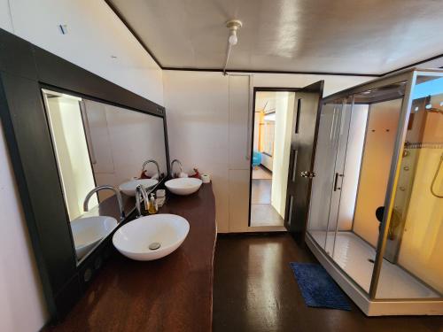 a bathroom with two sinks and two mirrors at Titicaca island lodge peru in Puno