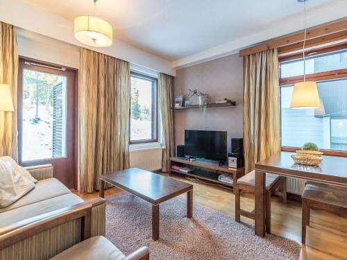 a living room with a couch and a table at Holiday Home Ylläs chalets 3210 by Interhome in Ylläs