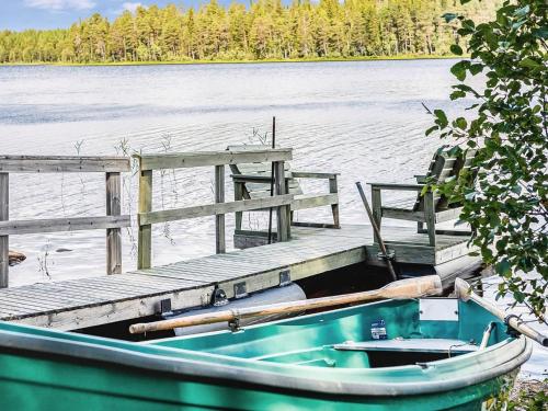 a boat sitting next to a dock on a lake at Holiday Home Piilola by Interhome in Raanujärvi