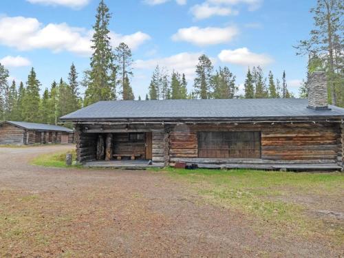 an old log cabin with a black roof at Holiday Home Metsä-luosto by Interhome in Luosto