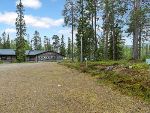 an empty road in front of a log cabin at Holiday Home Metsä-luosto by Interhome in Luosto
