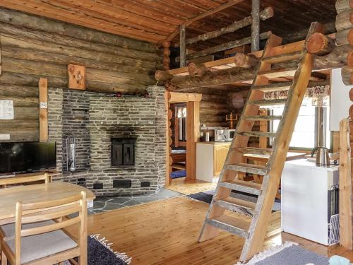 a living room with a ladder in a log cabin at Holiday Home Kulpakko 3 by Interhome in Tiainen
