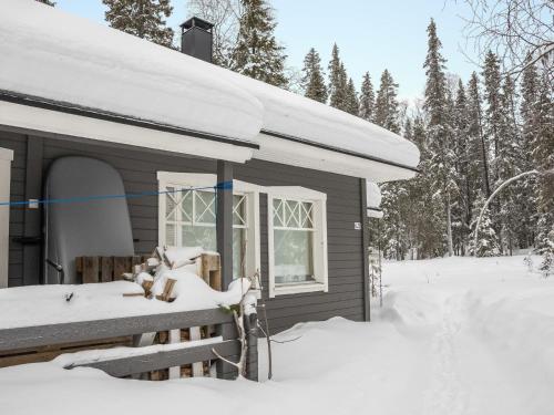 a cabin with snow on the roof in the yard at Holiday Home Tunturinvieri l3 by Interhome in Ylläsjärvi