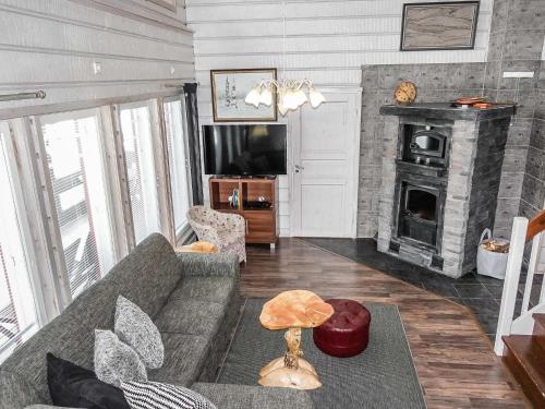 a living room with a couch and a fireplace at Holiday Home Kerkänperä by Interhome in Luosto