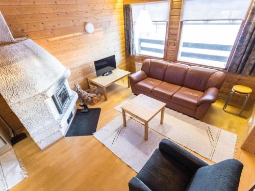 a living room with a couch and a fireplace at Holiday Home Tunturinvieri k2 by Interhome in Ylläsjärvi