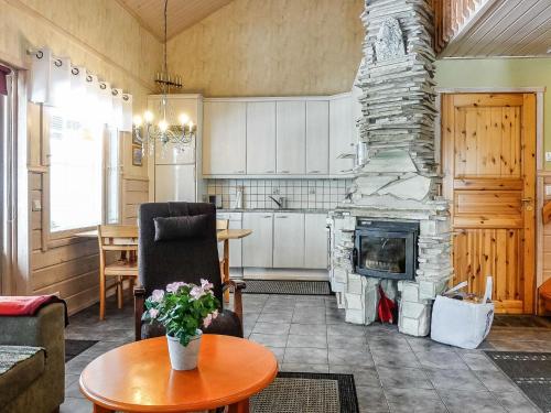 a kitchen and living room with a stone fireplace at Holiday Home Lustola a by Interhome in Luosto