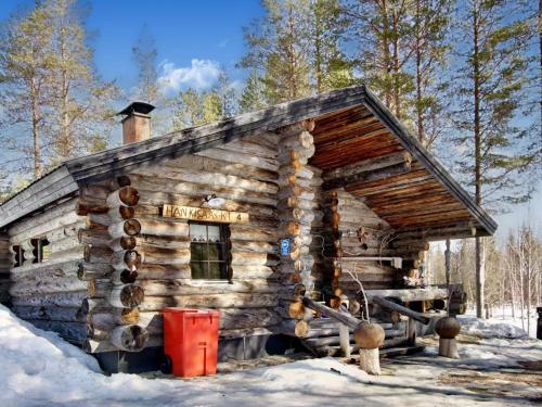 a log cabin in the snow with a red bucket at Holiday Home Hankisääski by Interhome in Ylläsjärvi