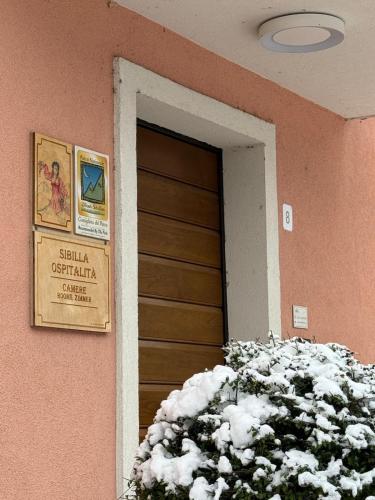 a door to a building with a bush in front of it at Sibilla Ospitalità in Visso