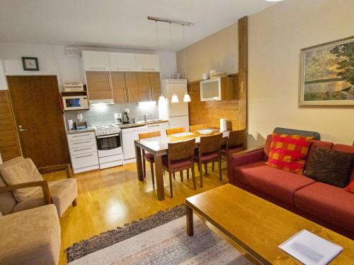 a living room with a red couch and a kitchen at Holiday Home Ylläs chalets a508 by Interhome in Ylläs