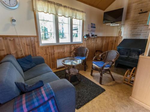 a living room with a blue couch and chairs at Holiday Home Meritähti by Interhome in Matildedal