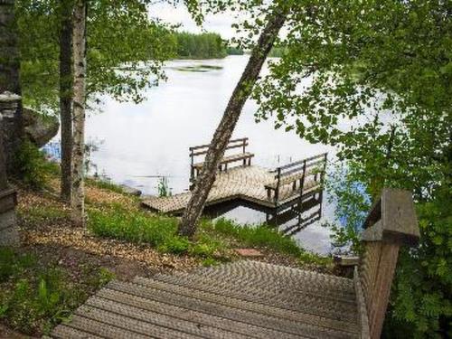 a bench sitting on a swing over a lake at Holiday Home Pernoo 1 by Interhome in Pernoo