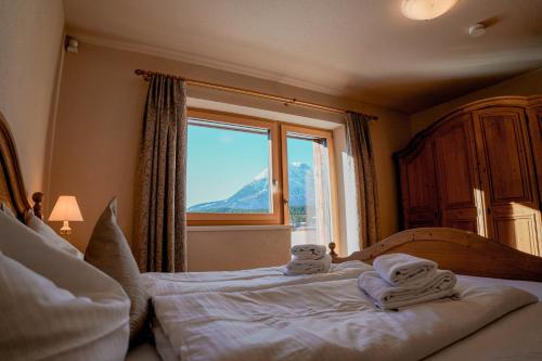 a bedroom with a bed with towels on it at AKTIV Apartments by Peak Stay in Leutasch