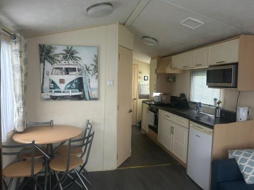 a small kitchen with a table and a kitchen with a caravan at Holiday home 5 minutes from Porth beach in Newquay Bay Resort