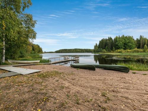 a lake with a dock and two boats on the shore at Holiday Home Koivuranta by Interhome in Jämijärvi