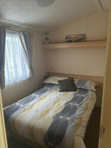 a bed sitting in a bedroom with a window at Holiday home 5 minutes from Porth beach in Newquay Bay Resort