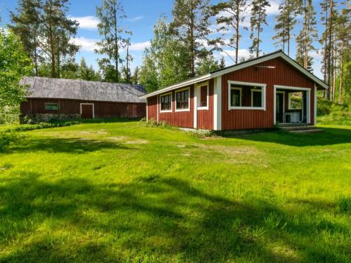 a red house with a large yard in front of it at Holiday Home 21 by Interhome in Varparanta