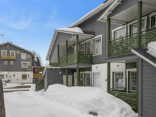 a house with a pile of snow in front of it at Holiday Home Ylläs-eeli green house c2 by Interhome in Ylläsjärvi