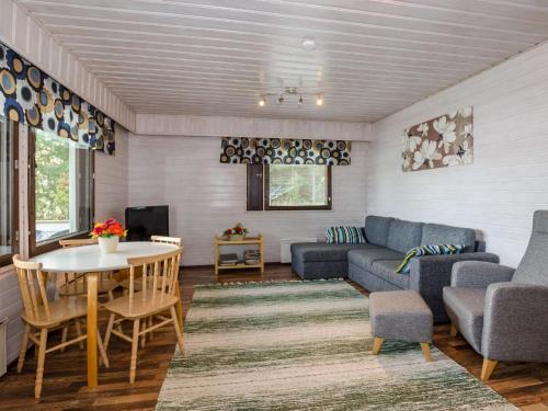 a living room with a couch and a table at Holiday Home Lomaranta by Interhome in Ruvaslahti