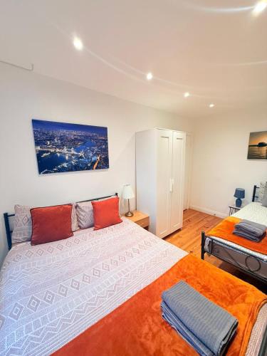 a bedroom with two beds with orange pillows at Notting Hill Guest Flat in Ealing