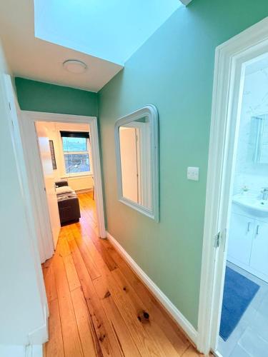 a room with a bathroom with a sink and a mirror at Notting Hill Guest Flat in Ealing