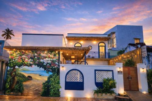 a large white house with a sunset in the background at Doc Bien Homestay Mui Ne - Entire Home in Ấp Khánh Phước (1)