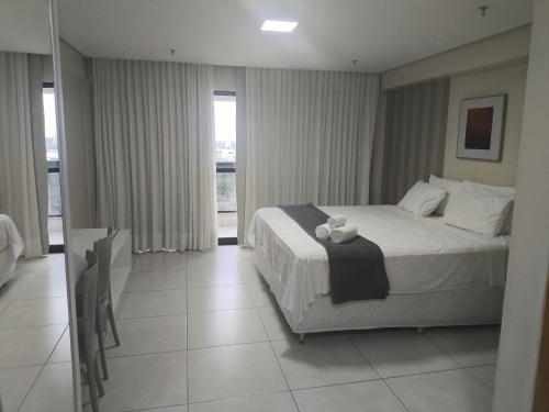 a bedroom with a bed with a teddy bear on it at Flat no Vivence Suites em Palmas in Palmas