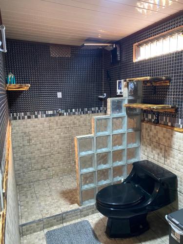 a bathroom with a black toilet in a room at Cabañas Tierra Fertil in Montaña
